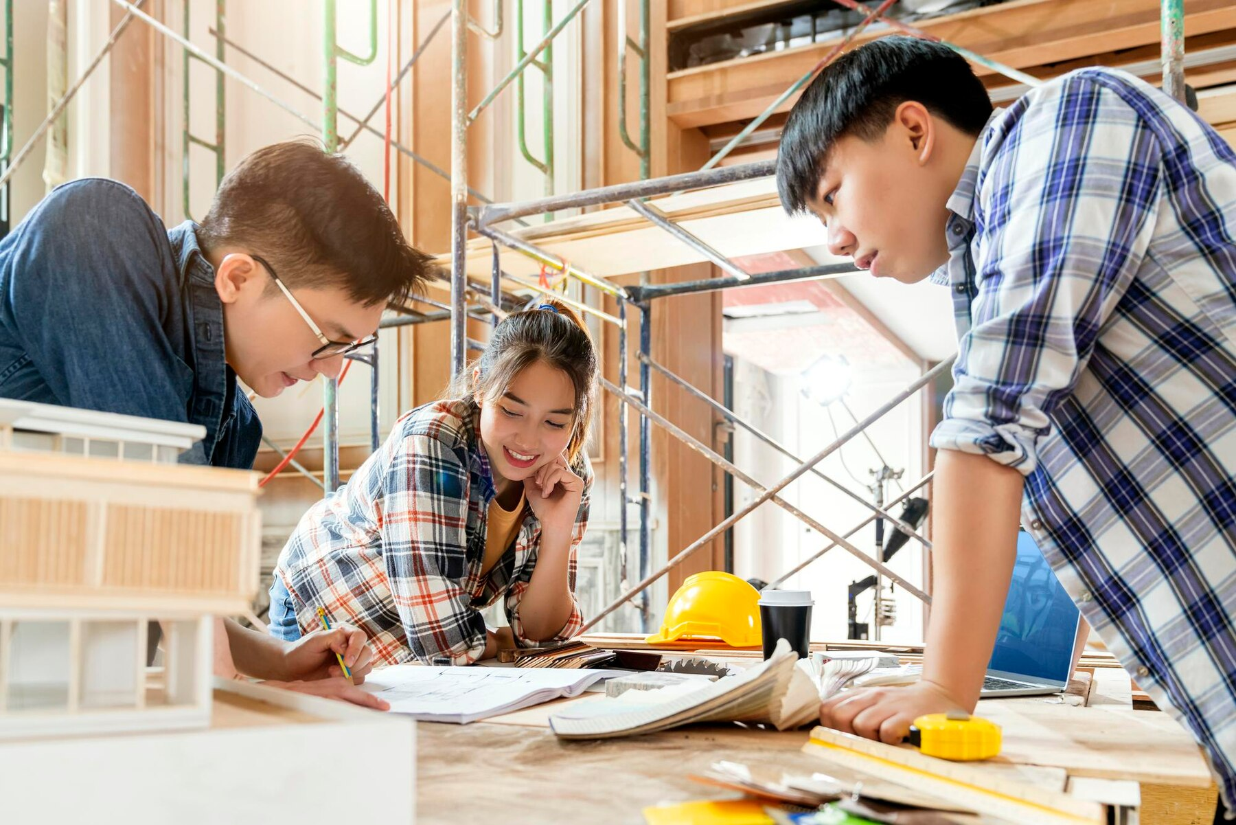 three young professionals reviewing construction plans